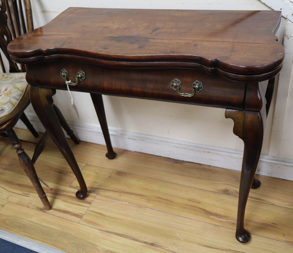 A George I red walnut serpentine top card table, with dished corners, frieze drawer and slender cabriole legs, width 82cm